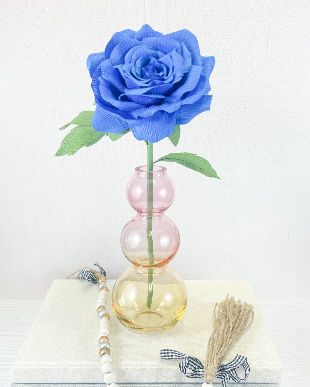 a blue rose sitting in a vase on a table