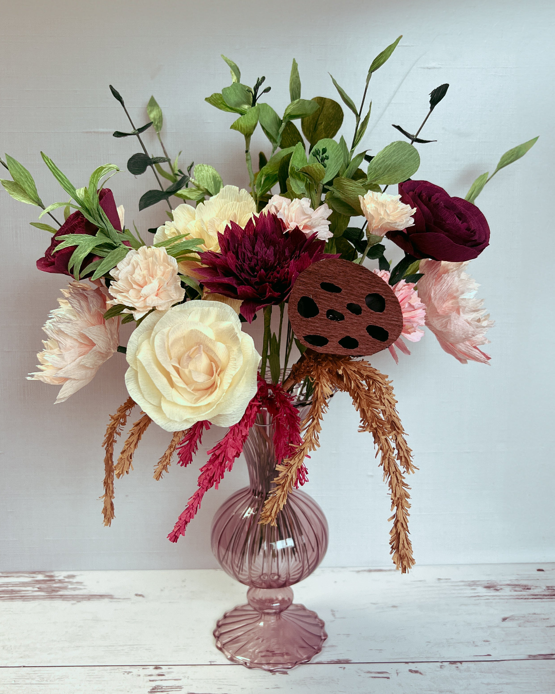 a vase filled with lots of flowers on top of a table