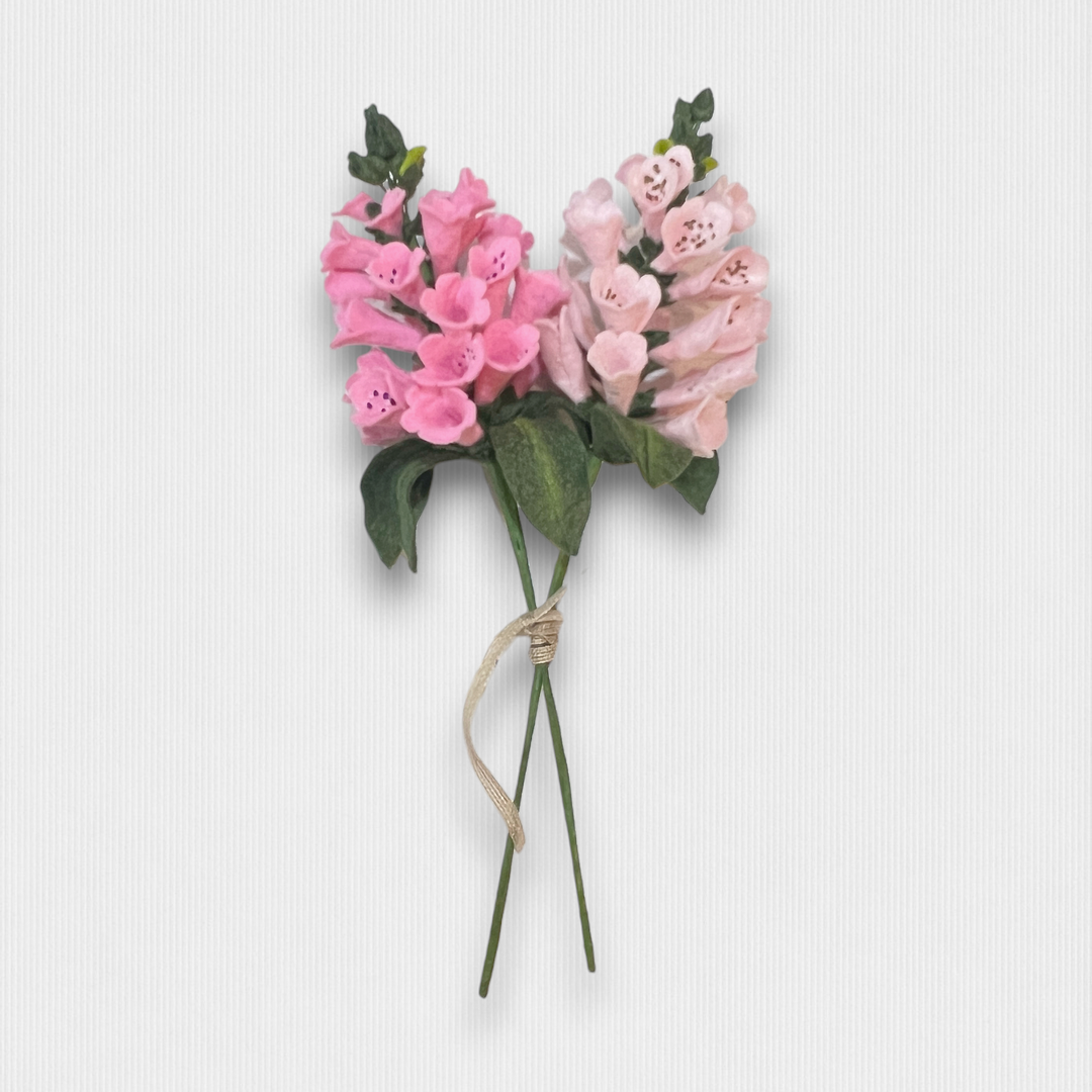 a bouquet of pink flowers tied to a white wall