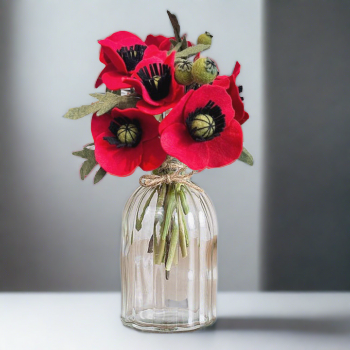 a vase filled with red flowers on top of a table