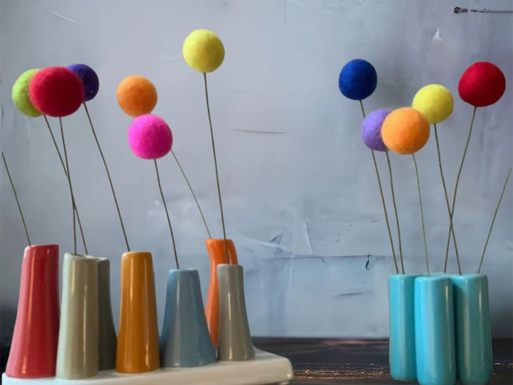 a group of vases with colorful balls in them