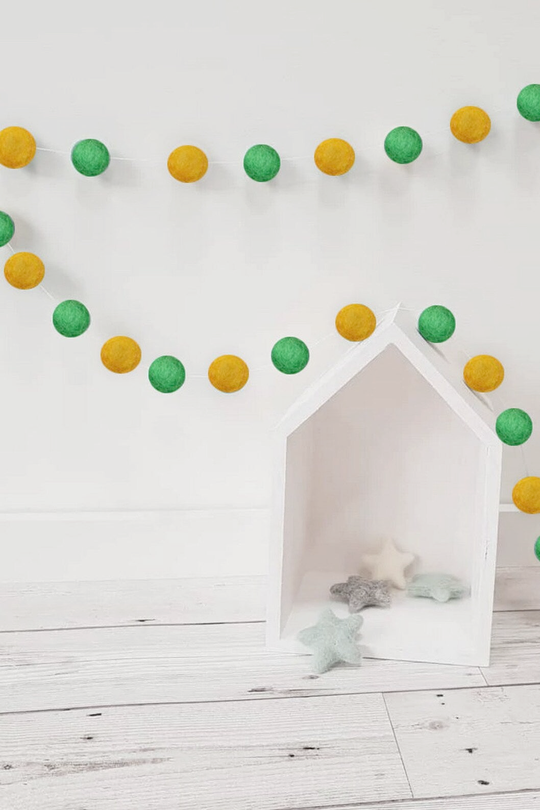 a white dog house with green and yellow decorations